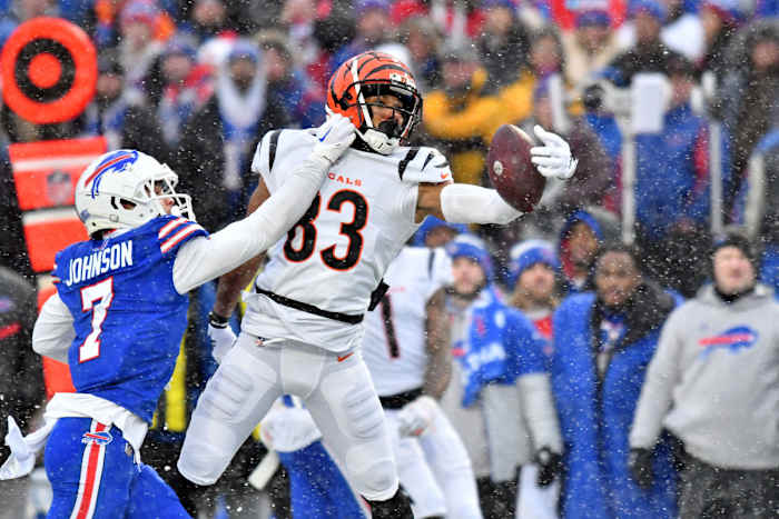 Cincinnati Bengals wide receiver Tyler Boyd (83) reaches for the ball while defended by Buffalo Bills cornerback Taron Johnson (7) during the first quarter of an AFC divisional round game at Highmark Stadium.